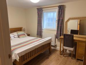 a bedroom with a bed and a desk and a mirror at The Crown Hotel in Corwen