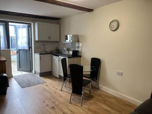 a kitchen with a table and chairs and a clock on the wall at The Crown Hotel in Corwen