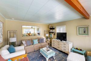 a living room with a couch and a tv at 4th Avenue Beach Cottage in Rockaway Beach