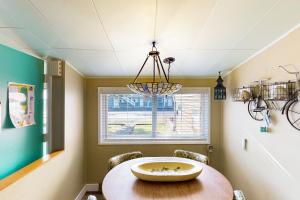 a dining room with a table and a chandelier at 4th Avenue Beach Cottage in Rockaway Beach +20 photos