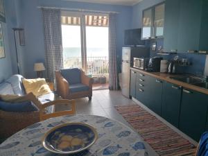 a kitchen with a table and a kitchen with a view of the ocean at A 10 passi dal mare in Ventimiglia