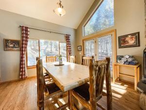 a dining room with a wooden table and some windows at Trail in Woodland Park