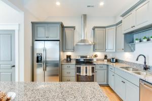 a kitchen with white cabinets and a stainless steel refrigerator at 408A The Boardwalk House in Virginia Beach