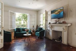 a living room with green chairs and a fireplace at Yogi hostels in Santiago