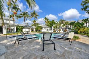 Un grupo de sillas junto a una piscina. en Relaxation & Luxury Pool GYM Parking WIFI, en Deerfield Beach