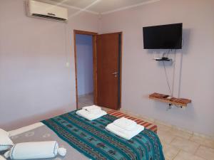 a bedroom with a bed with a tv on the wall at Casa de Cande in Tandil