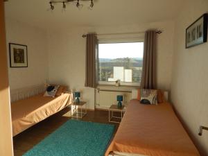 two beds in a room with a window at Ferienwohnungen Ferienhaus Nähe Winterberg Upland in Bromskirchen