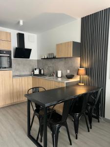 een keuken met een zwarte tafel en zwarte stoelen bij Apartament 44 in Szczecin +5 foto's