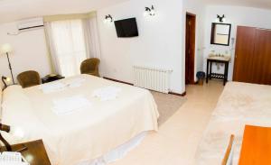 ein Hotelzimmer mit einem Bett mit Handtüchern darauf in der Unterkunft Panacea Hotel in Villa General Belgrano