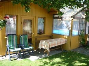 a house with two chairs and a table in the yard at FEWO Prackenbach in Prackenbach