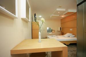 a room with a bed and a vase with flowers on a table at Floresta Tucuruvi (Adult Only) in Sao Paulo