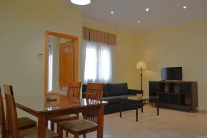 ein Wohnzimmer mit einer Couch und einem Tisch und Stühlen in der Unterkunft Sunshine Corredera in Córdoba
