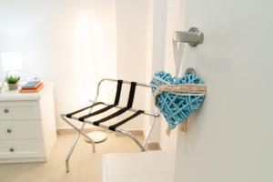 a heart hanging on a wall next to a chair at DanysHome Circe davanti al mare in Terracina