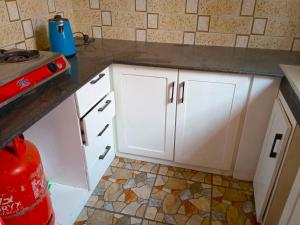 NkunjilaにあるBleivory Homes1の白いキャビネットとカウンター付きのキッチン
