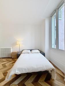 a white bedroom with a bed and a window at Gordes Centre-Historique téléphérique in Grenoble