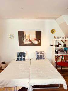 a bedroom with two beds and a painting on the wall at Apartamento centro histórico Porto in Porto