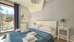 een slaapkamer met een bed met handdoeken erop bij Apartamenty Pod Gubałówką in Zakopane