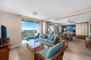 a living room with a blue couch and a table at Kailua Village#705 in Kailua-Kona