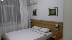 a bedroom with a bed with white pillows on it at Sakura Inn in Fergana