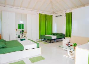 a bedroom with two beds and green curtains at The Heavens Bungalow Katunayake in Katunayake