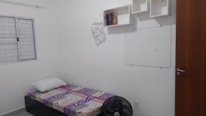 a room with a small bed in a white wall at House grey proximo Holambra UNASP in Artur Nogueira