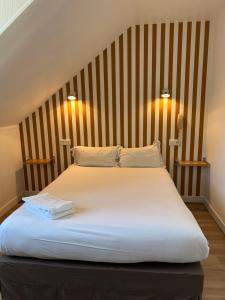 a bedroom with a large white bed with a wooden headboard at Hotel Eden in Saint Malo +75 photos