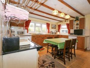 eine Küche mit einem Tisch und einem grünen Tischtuch in der Unterkunft Dalar Cottage in Brynkir