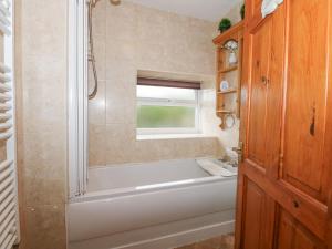 ein Badezimmer mit Badewanne und Fenster in der Unterkunft Dalar Cottage in Brynkir + 24 Fotos