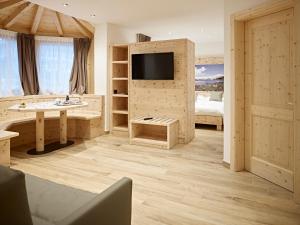 a large bathroom with a television and a bedroom at B&B Augusto in Madonna di Campiglio