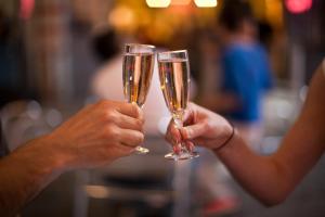 two people holding champagne glasses in their hands at Colonial Inn in Ogunquit