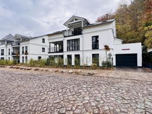 een groot wit huis op een geplaveide straat bij Ferienwohnung Meereslauschen in der Villa Beatrice in Binz