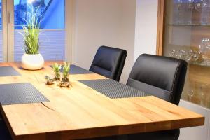 un tavolo di legno con due sedie nere intorno di Ferienwohnung Strandnest in der Villa Gudrun Binz a Binz