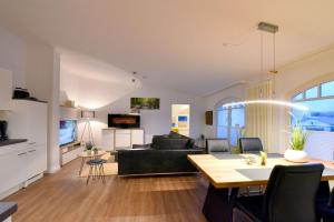 un soggiorno con un divano nero e un tavolo di Ferienwohnung Strandnest in der Villa Gudrun Binz a Binz