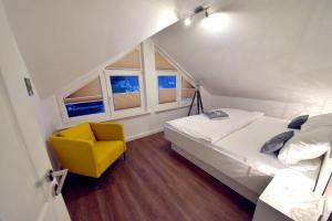 una camera da letto con un letto e una sedia gialla di Ferienwohnung Strandnest in der Villa Gudrun Binz a Binz