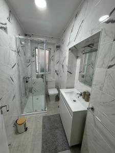 un bagno con doccia, lavandino e WC di Chalé do Tejo a Moita