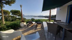 a patio with a table and chairs and a view of the water at AbuNagia seaside villa garden in Erice