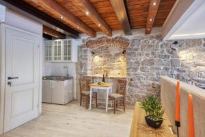cocina con mesa y pared de piedra en Apartman Sun 2, en Šibenik