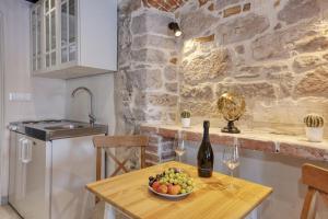 una mesa con un bol de fruta y una botella de vino en Apartman Sun 2, en Šibenik 4 fotos más