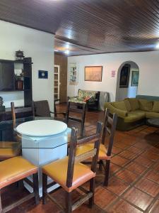 a living room with a table and chairs and a couch at Chácara Samambaia Piracicaba in Piracicaba