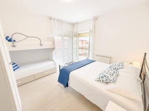 a white bedroom with a bed and a window at DanysHome Giove davanti al mare in Terracina