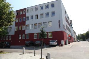 ein rotweißes Gebäude mit davor geparkt in der Unterkunft Hotel am Charlottenplatz in Esslingen