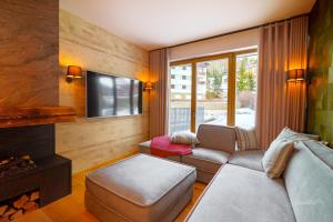 a living room with a couch and a fireplace at Apartmán Skalka na Šumavě, Železná Ruda in Železná Ruda