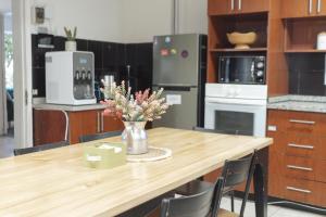 a kitchen with a table with a vase of flowers on it at Yogi hostels in Santiago