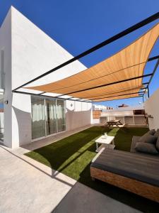 a patio with awning on the side of a house at CORRALEJO SURF HOUSE & SCHOOL only SURF in Corralejo