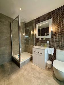 a bathroom with a shower and a toilet and a sink at Hebden Townhouse in Hebden Bridge