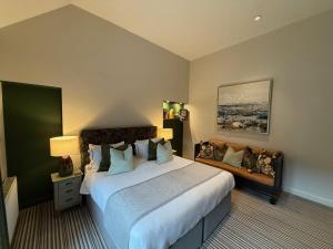 a hotel room with a large bed and a couch at Hebden Townhouse in Hebden Bridge