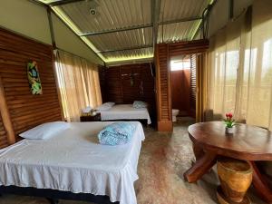 a bedroom with two beds and a table in it at Cabaña 3 venado in Venado