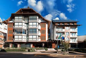 an apartment building in front of a building at Hotel Cercano in Gramado
