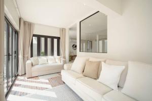 a living room with a white couch and a mirror at Somewhere house in Bangkok +64 photos