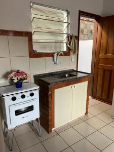 una cucina con una stufa bianca e un lavello di Casa Jacaraipe 100 m da praia a Serra